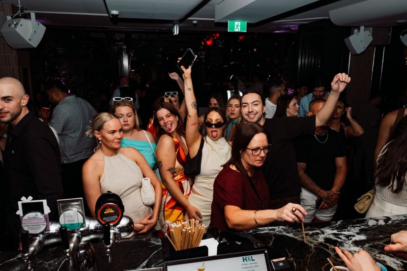 Crowd at the bar with hands in the air