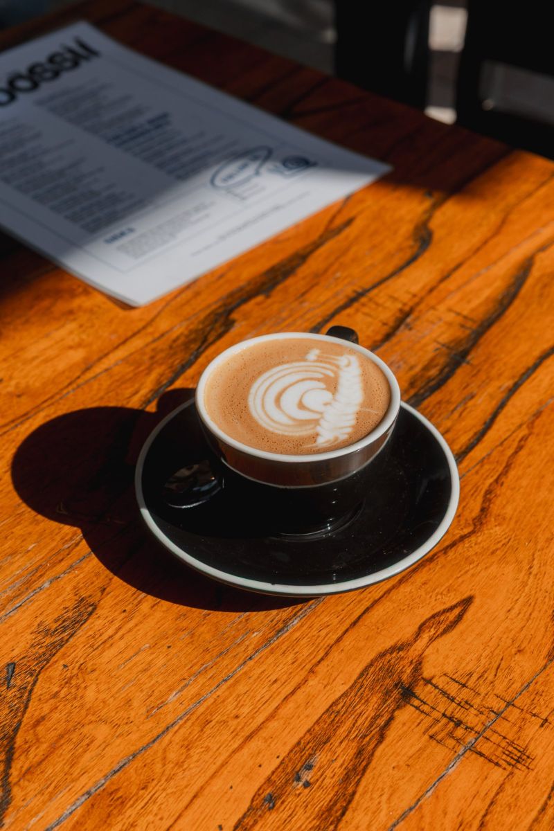Latte in afternoon sun on a timber table