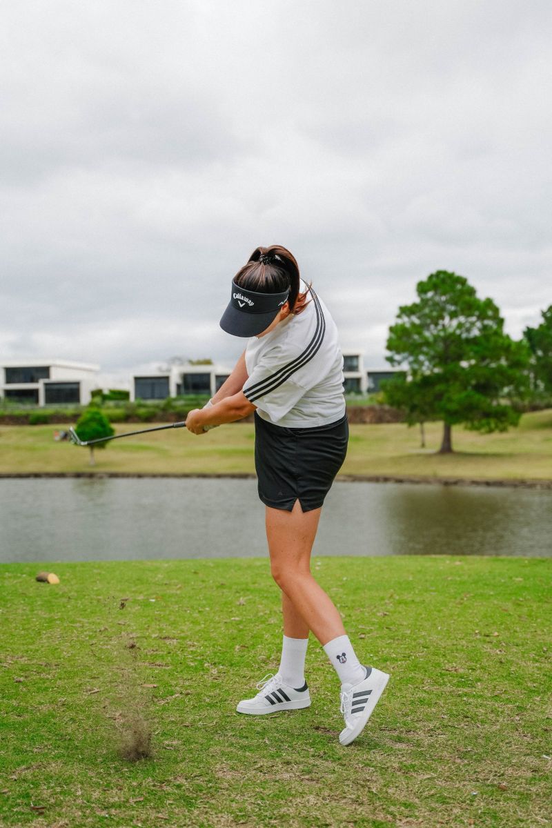 Iron shot follow-through by the lake, divot flying