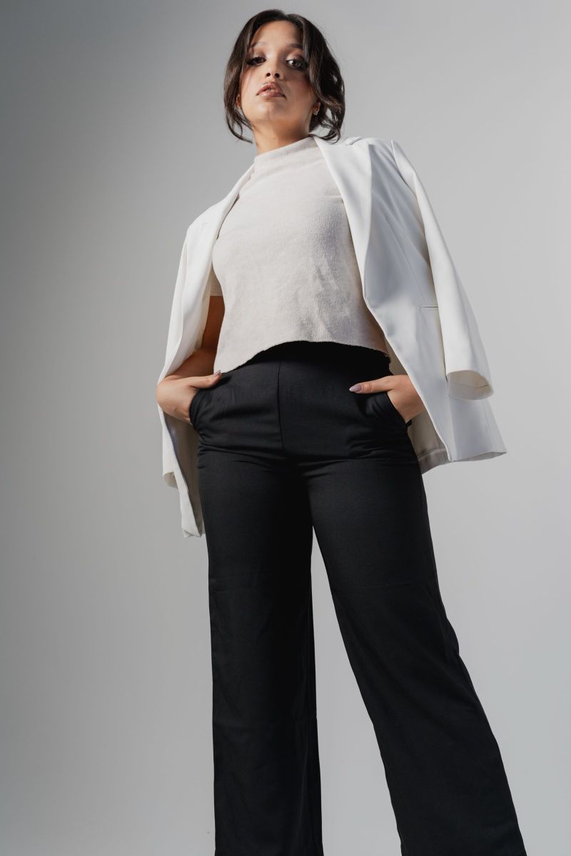 Low-angle studio portrait in a white blazer