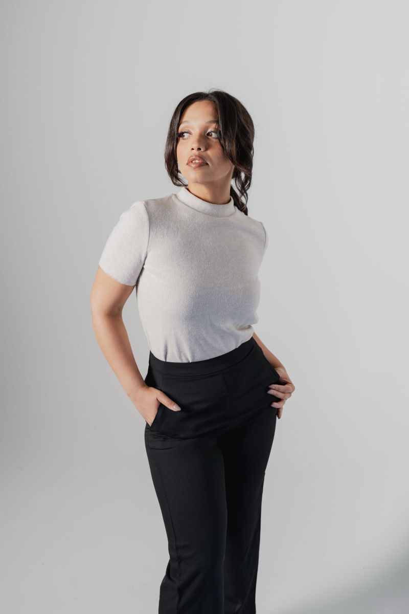 Studio portrait in a white tee and black trousers