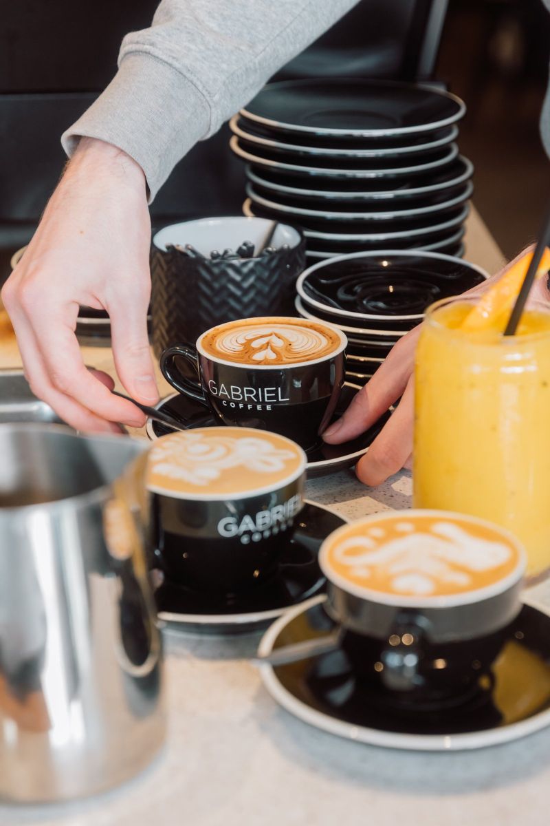 Gabriel Coffee cups and a fresh juice on the counter