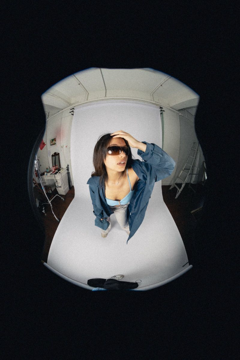Fisheye studio shot, model in a blue jacket and shield sunglasses