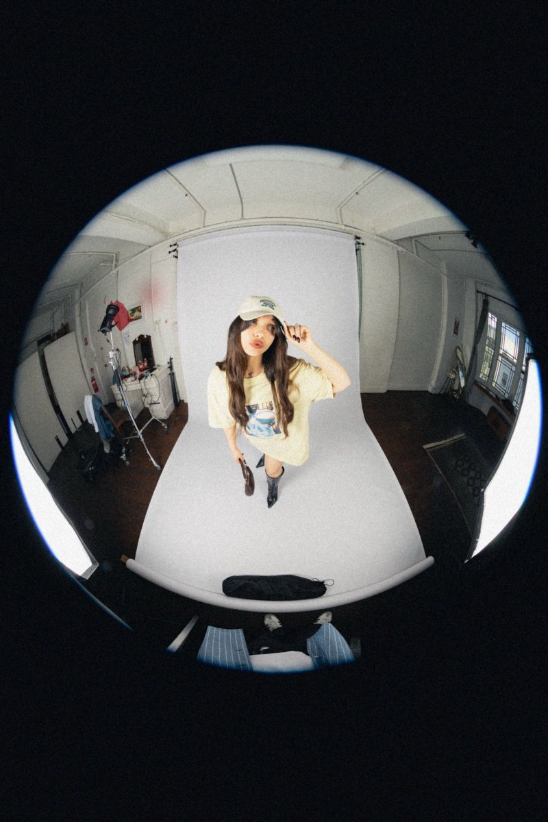 Fisheye studio shot, model in a cap and yellow tee